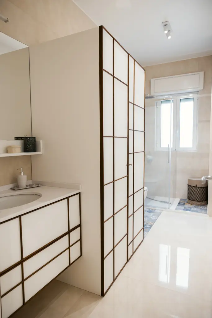 Bagno moderno con mobile lavabo e armadio a struttura in legno e vetro opaco.