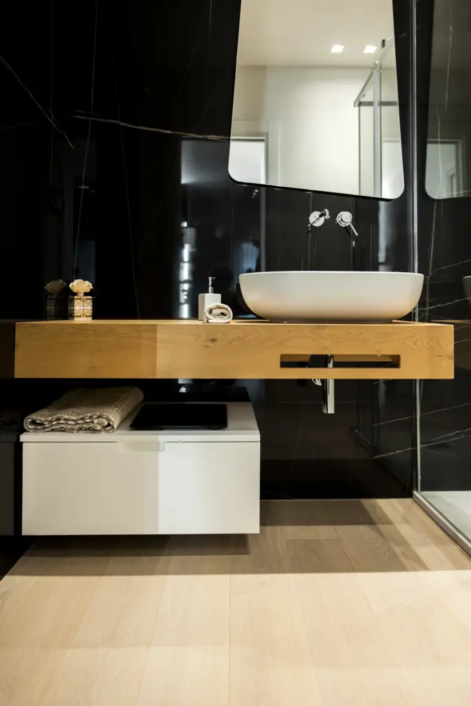 Bagno moderno con lavabo sospeso bianco, piano in legno e dettagli di design minimalista.