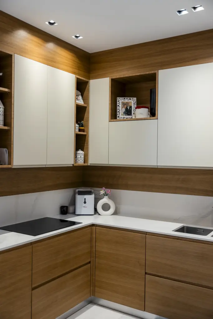 Vista di cucina moderna modulare con ante in legno e bianco e piano in marmo.