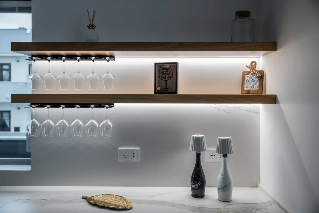 Mensole cucina in legno con portabicchieri integrato e illuminazione LED, su parete in marmo chiaro