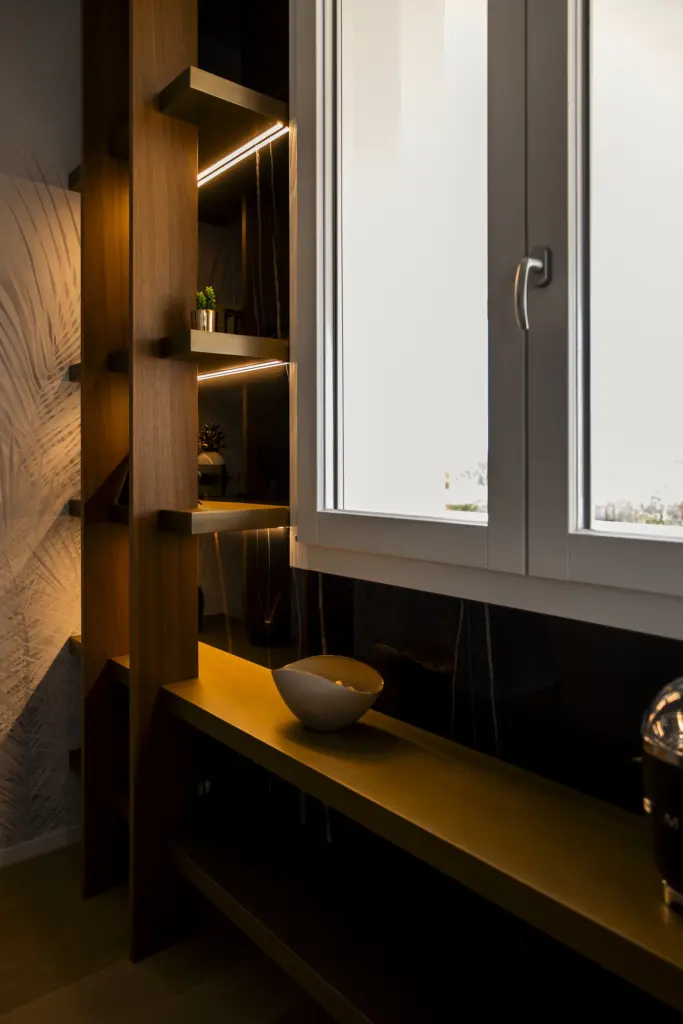 Libreria in legno su misura con mensole illuminate da luci LED calde.