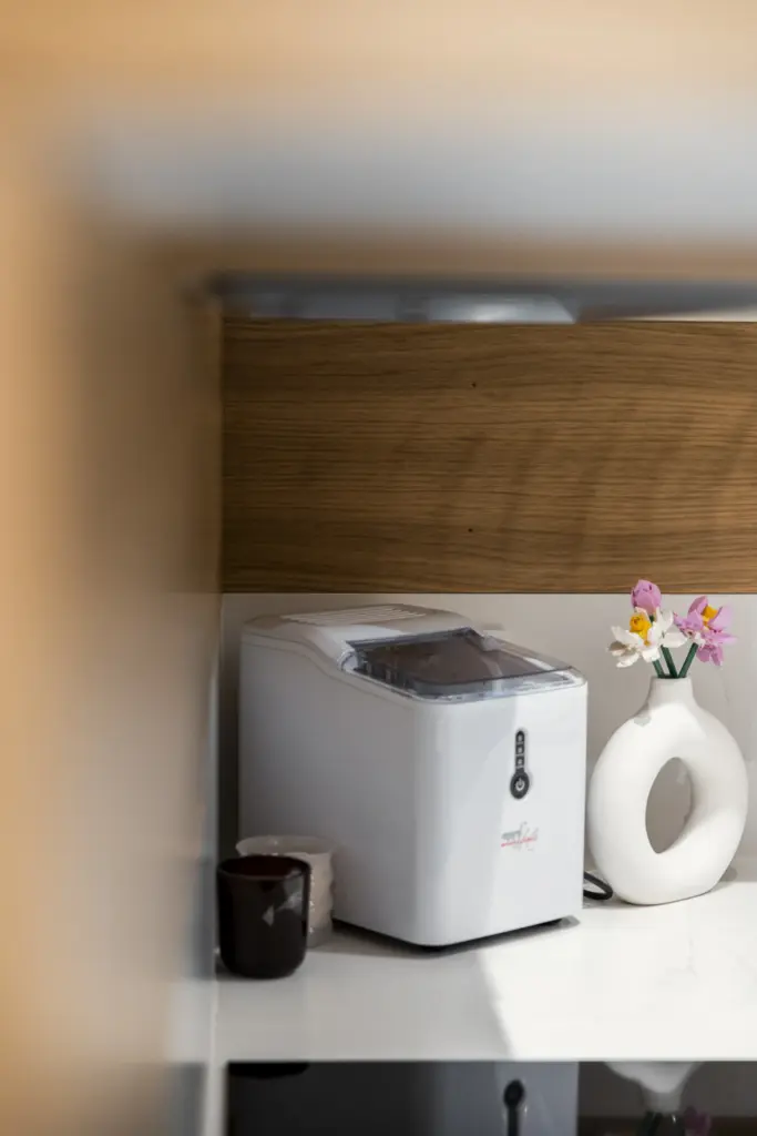 Macchina per il ghiaccio su piano cucina effetto marmo con elementi decorativi.