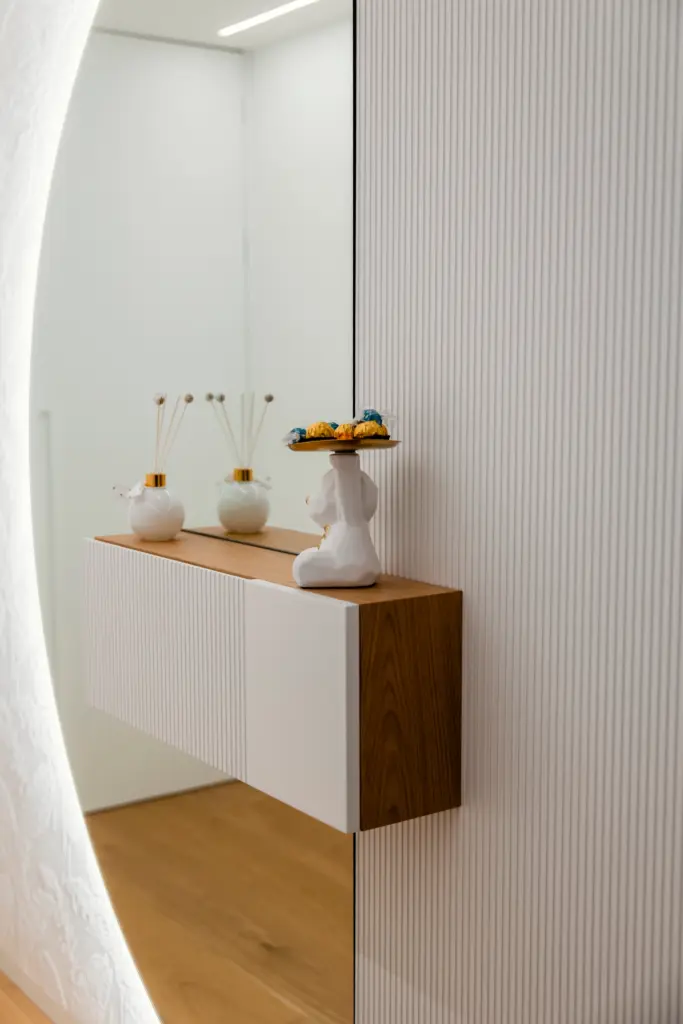 Mobile sospeso da ingresso con finitura in legno e bianco opaco, specchio retroilluminato e decorazioni moderne