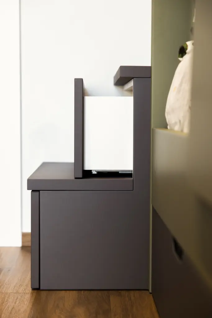 Dettaglio di panca modulare in legno verniciato grigio e bianco per arredamento moderno.